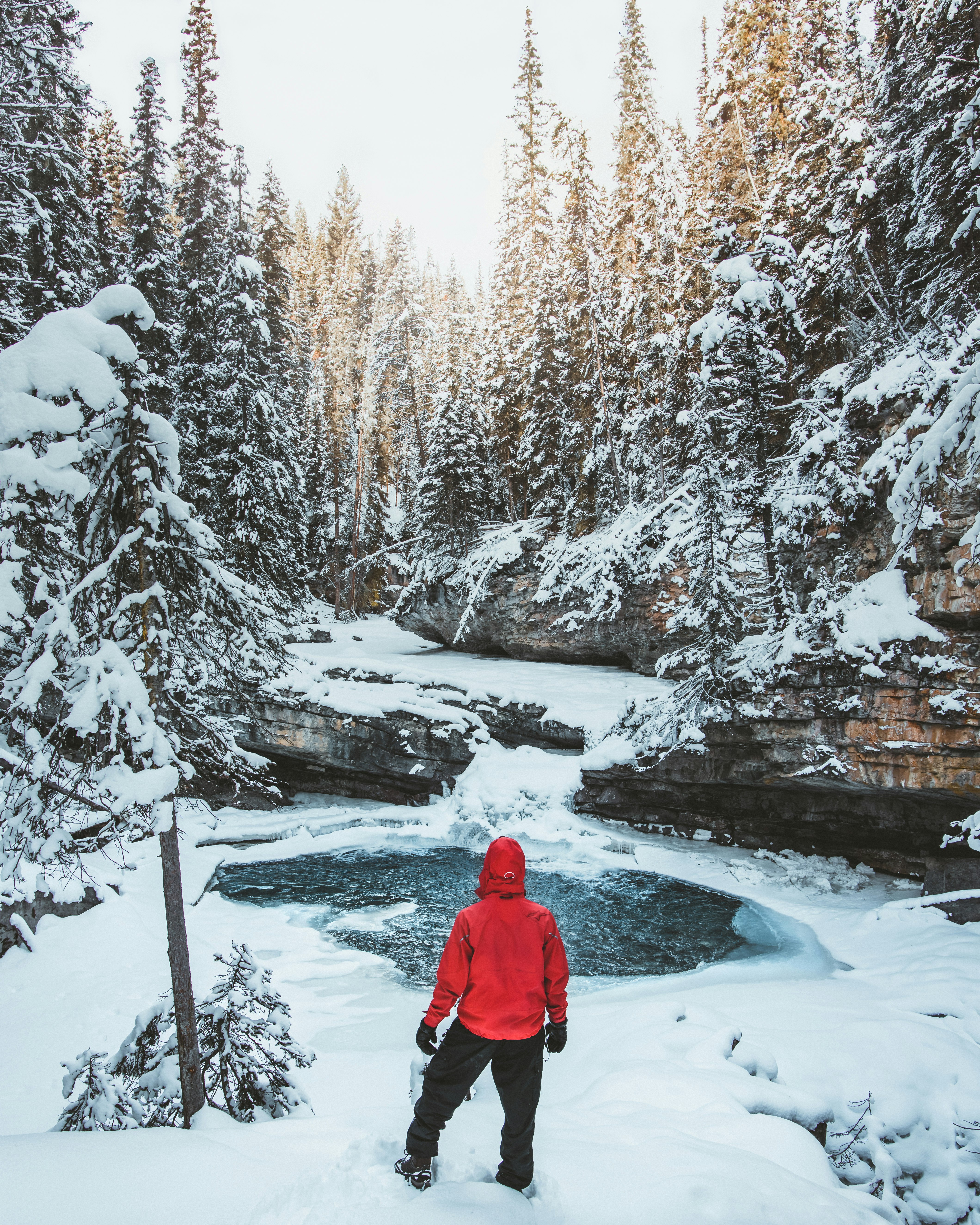 person in blue hoodie standing on ground covered by snow during daytime